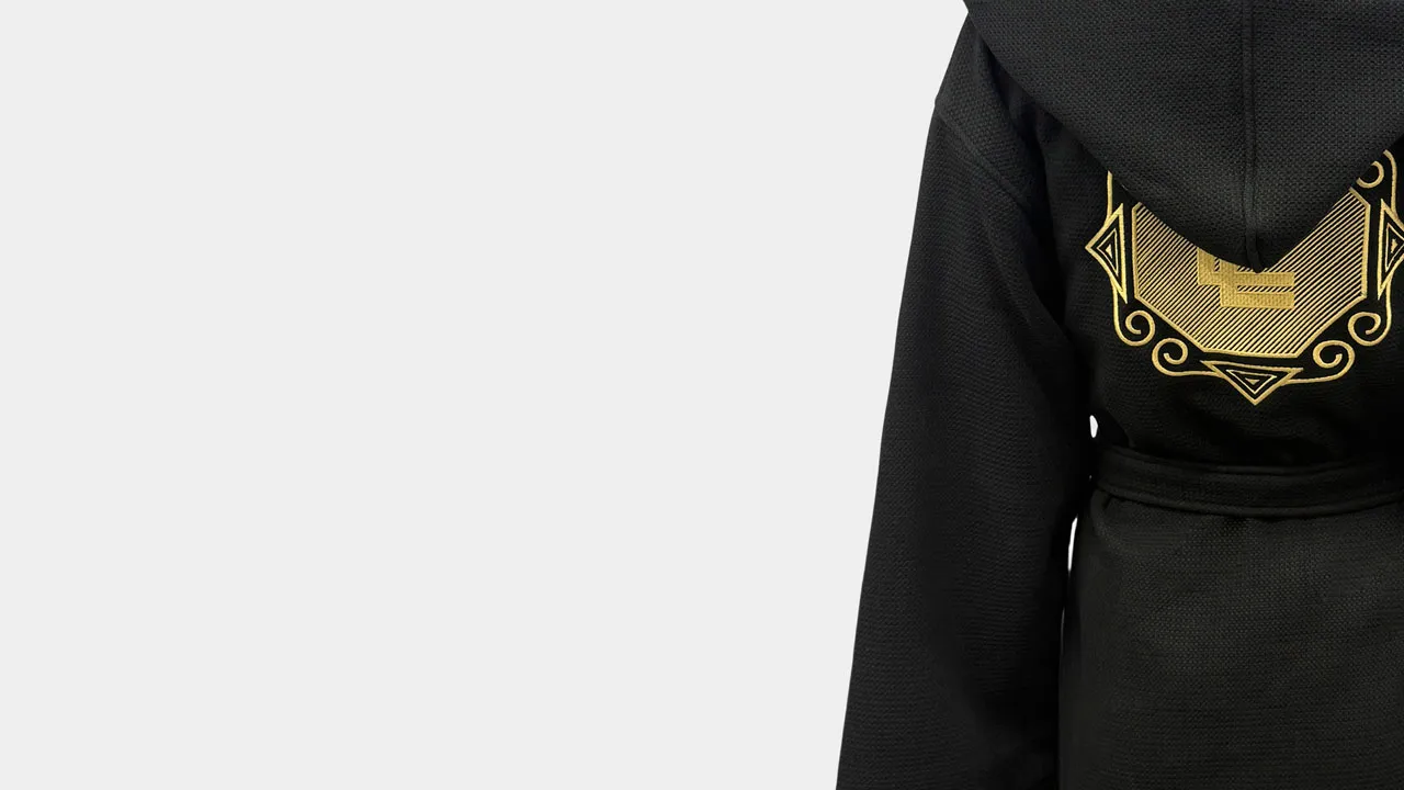 Black waffle bathrobe with gold embroidery detail for custom hospitality and private-label programs.