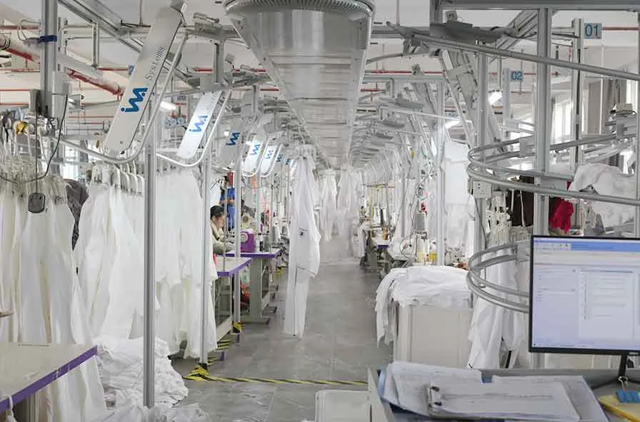 Softextiles garment making line producing bathrobes in a controlled factory environment.
